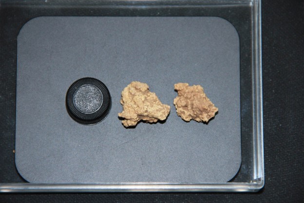 Two clumps of hardened preserved cheese chunks on a metal dish. The clumps look more like nuggets of gold, with a sandy color. Two clumps of hardened preserved cheese chunks on a metal dish. The clumps look more like nuggets of gold, with a sandy color.